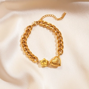 Detailed close-up of golden stainless steel chain bracelet with star and heart charms