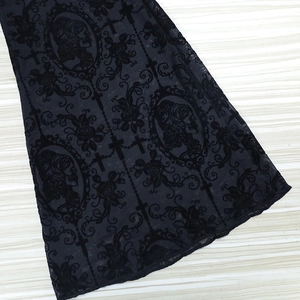 Detailed close-up of gothic lace fabric with velvet silhouettes and floral vine motifs