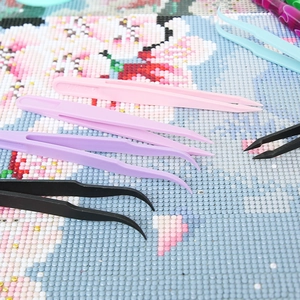 Colorful plastic tweezers set for diamond painting with straight and curved tips on canvas