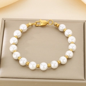 Detail of freshwater pearl bracelet with gold beads and lobster clasp on gift box
