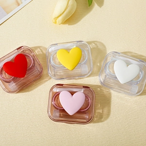 Transparent heart-shaped contact lens cases in red, yellow, pink, and white colors