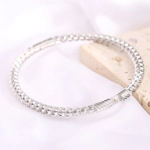 Detailed close-up of 5mm silver stainless steel bangle with textured diamond-cut finish