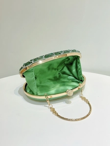 Detail of green rhinestone peacock clutch with gold frame and green satin lining interior