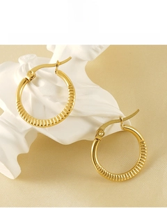 Detail showing the ribbed texture of 18K gold plated hoop earring on a white plaster bust