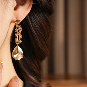 Close-up of elegant V-shape pear cut champagne crystal drop earrings on a model