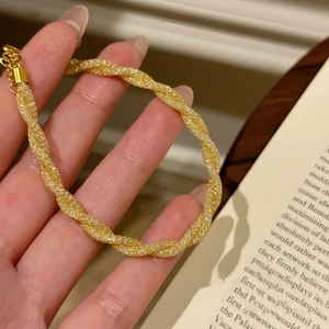 Detail of gold twisted rope bracelet with sparkling stones and lobster clasp closure