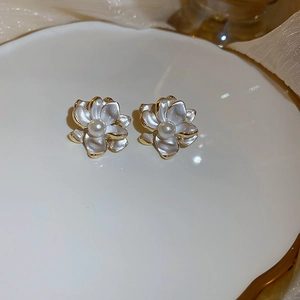 Detailed macro view of the camellia flower earrings with gold edges and pearl centers
