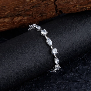 Elegante bracciale in argento con cristalli marquise e tondi su sfondo di legno scuro