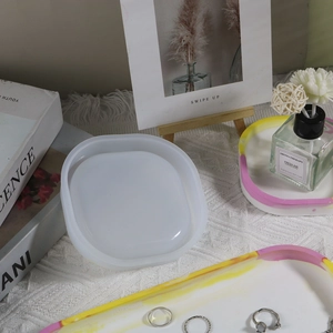 Detail of oval resin tray mold showing white silicone texture and finished DIY crafts