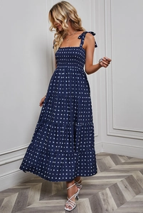 Detail of navy blue gingham dress featuring bow straps and elastic smocked bodice