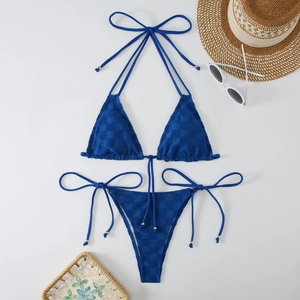 Detail of navy blue checkered bikini with halter top, side-tie bottoms and beach accessories