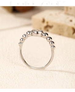 Macro shot of silver bubble ring featuring a bezel-set moissanite stone and polished beads