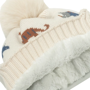Close-up of beige knitted toddler hat with dinosaur pattern and warm fleece lining