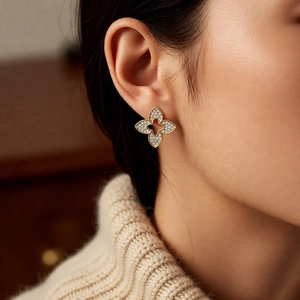 Macro view of gold-plated flower stud earrings with pave-set cubic zirconia petals