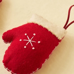 Red felt Christmas mitten ornament with white snowflake embroidery and hanging loop