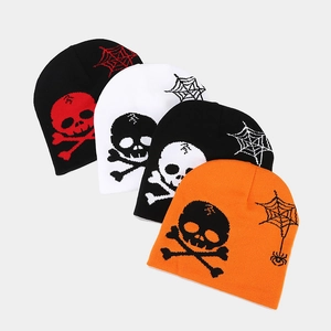 Detail of four knit beanies featuring jacquard skull and spider web holiday patterns