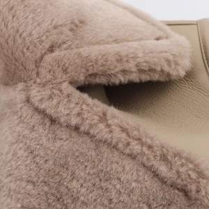 Close-up of beige faux fur and leather texture on a reversible double-breasted coat