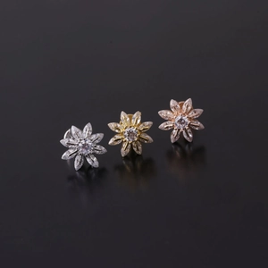 Detailed macro shot of 16G stainless steel labret studs with cubic zirconia flower designs