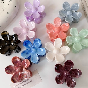 Vue détaillée de l'ensemble de 10 pinces à cheveux fleur à texture marbrée sur table