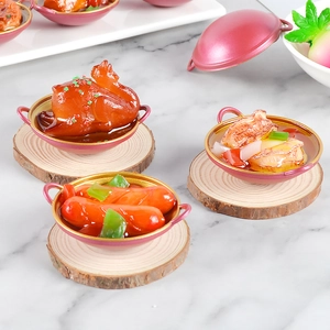 Miniatur-Puppenhaus-Essen mit Brathähnchen und Meeresfrüchten in rosa Pfannen