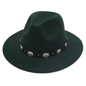 Détail d'un chapeau fedora vert foncé avec bande en cuir noir et disques en métal vintage