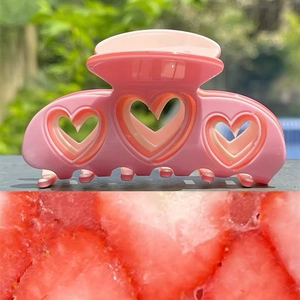 Y2K sweet Barbie pink heart-shaped cutout hair claw clip shown against a natural background