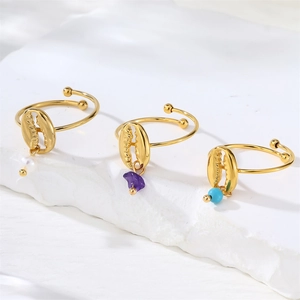 Detailed view of three 18k gold-plated shell rings with pearl and turquoise dangles
