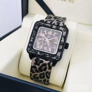 Close-up of square leopard print watch featuring a black case and gold hands in a gift box