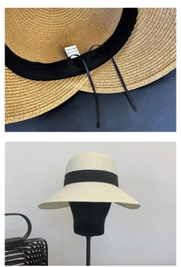 Detail view showing adjustable strap and black ribbon on beige woven straw sun hat