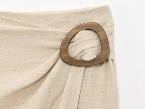 Dettaglio del girovita su gonna in lino con una fibbia in legno marrone dal design unico
