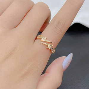 Detail of gold lightning ring with zircon pave setting and adjustable open band design