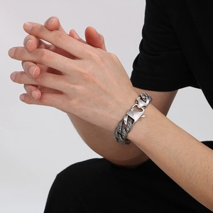 Retro vintage silver chain bracelet with engraved scroll pattern on male model's wrist