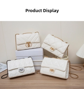 Detailed view of white quilted faux leather crossbody bags with golden chain straps