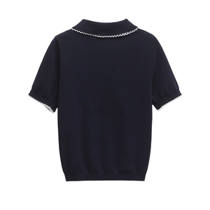 Detail of navy knit polo shirt with white wavy scalloped lace trim on collar and sleeves