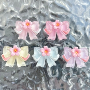 Detailed view of assorted resin bowknot accessories with floral centers for DIY crafts