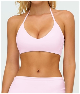 Nahaufnahme des rosa Halter-Sport-BHs mit V-Ausschnitt und angerauter Stoffstruktur