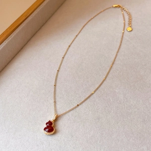 Vue macro collier hulu plaqué or avec pendentif en agate rouge et pierre de zircon