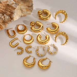 Collection of golden C-shaped, twisted hoop and U-shaped earrings with zircon details