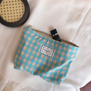 Detail of blue and orange checkered cosmetic bag with TIME TO PARTY label on a knit background