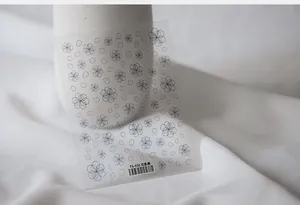 Detail of TS-030 5D nail art stickers with black floral line patterns on white fabric