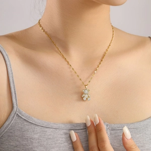 Elegant gold bear pendant necklace with full micro-pave crystals on a leaf-style chain