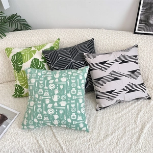 Detailed view of four modern cotton linen pillow covers with green leaf and geometric patterns