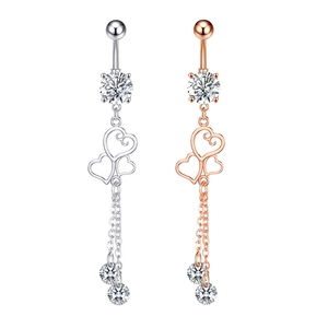 Detail of silver and rose gold belly rings with heart patterns and zircon tassels