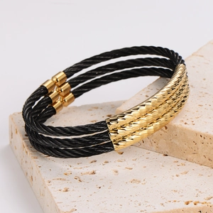 Minimalist black stainless steel cable bracelet with gold textured magnetic clasp