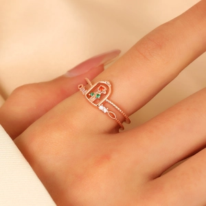 Detail of rose gold double ring featuring a red rose inside an openwork dome structure