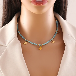 Bohemian turquoise bead necklace with gold butterfly pendants on a fashion model