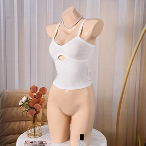 Détail du haut court en tricot blanc montrant la coupe ajourée sur le tissu doux