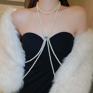 Detail of multilayer pearl body chain with a blue heart gemstone on a model