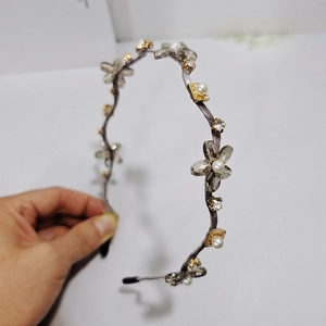 Detailaufnahme von grauem Kristallblumen-Haarreif mit Perlen und Gold-Akzenten