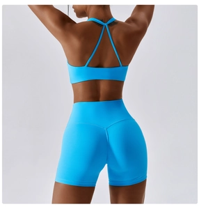 Detail of blue sports bra with cross back straps and high-waist yoga shorts